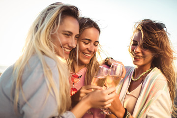 Friends having fun with champagne at celebration on beach, selective focus.