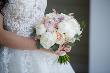 Beautiful wedding bouquet of flowers in the hands of the newlyweds