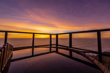 Fototapeta na wymiar An amazing an idyllic view a wooden hot tub waiting us for some relaxation time during sunset and twilight before an awe night sky with a small crescent moon. A leisure activity at Chilean coastline