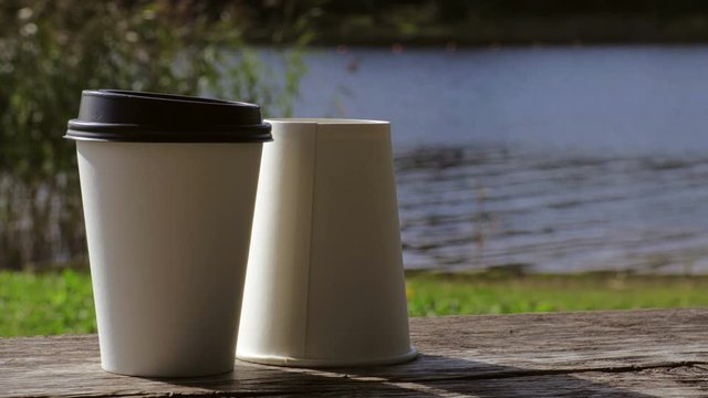 Two take away coffee cups on bench