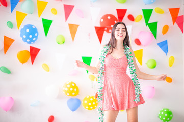 Cheerful young women celebrating new years with background flags and balloon colorful