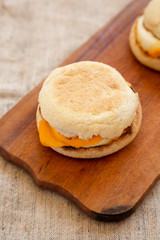 Homemade egg sandwich with cheese on a rustic wooden board, low angle view. Closeup.