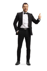 Young elegant man in a suit and bow showing thumbs up