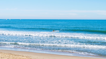 Young guy is going to surf in mediterranean sea.