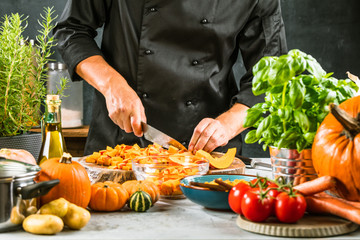 Chef cutting fresh and delicious pumkin and vegetables for cooking soup