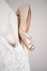 Hochzeitskleid und Hochzeitsschuhe hängen an einer Altbautür