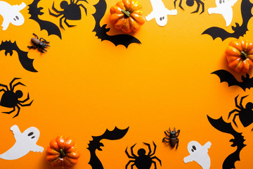 Happy halloween holiday concept. Halloween decorations, spiders, pumpkins, bats, ghosts on orange...