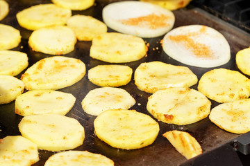 Potatoes cut to thin slices grilled on electric grill