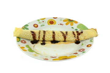Pancake or crepe filled with cream and chocolate syrup. Pancakes with chocolate isolated on white background.