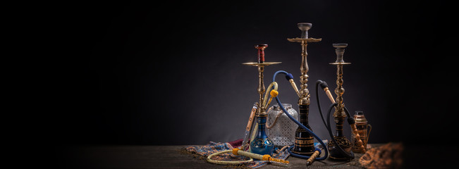 Rustic handmade hookah and arabic tea for relaxation in a dark moody room, rustic decoration, smoke and shisha components