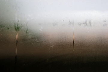 Steam on the glass on a rainy day. Water droplets condensation on window. for texture or background.