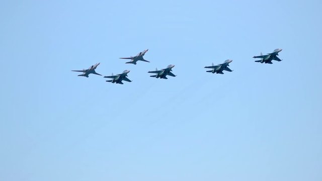 Column of six military warplanes flies over the ground. Military helicopters and planes in the evening sky. Air force parade. Independence Day parade in the CIS country. Belarus 3 July 2019.