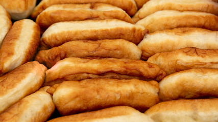 Background the food consists of delicious fried pies stuffed with yeast. Delicious, soft, fluffy, pies with filling, handmade.