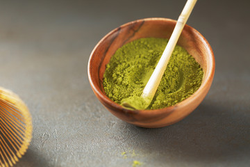 Close up powder of matcha tea is partially dissolved in hot water