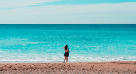Frau steht am Strand