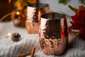 A cup of hot chocolate or tea and coffee on a warm wool blanket, with a Christmas background and atmosphere