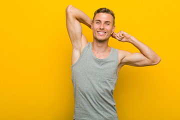 Young caucasian sport man stretching arms, relaxed position.