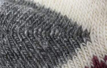Knitted soft woolen sock as background, closeup