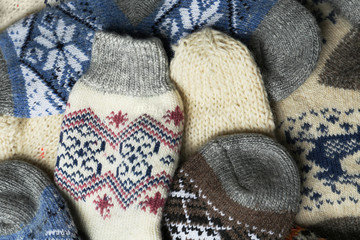 Different knitted woolen socks as background, closeup