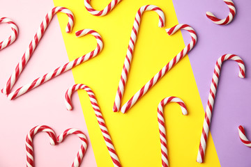Flat lay composition with candy canes on color background