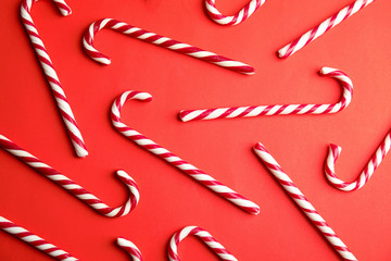 Candy canes on red background, flat lay