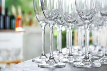 Empty glasses on wooden table against blurred background, closeup view