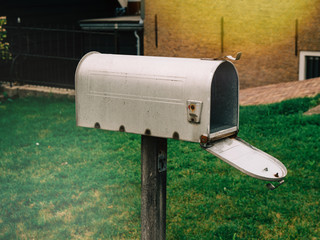 Side view of traditional american style open mailbox in front of the house with no letters or newspapers parcels inside