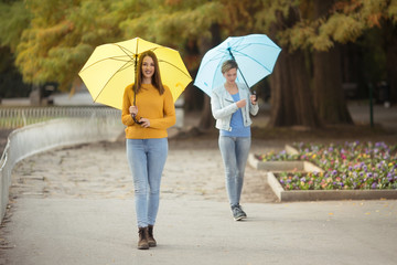 Young women with umbrella in park