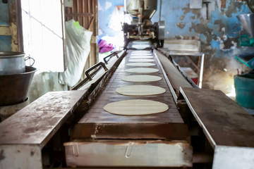 Fototapeta na wymiar La maquina para hacer tortillas de maíz es muy vieja. 