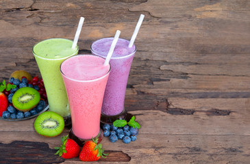 Strawberry kiwi and blueberry  smoothies colorful fruit juice milkshake blend beverage healthy high protein the taste yummy In glass,drink episode morning on wood background.