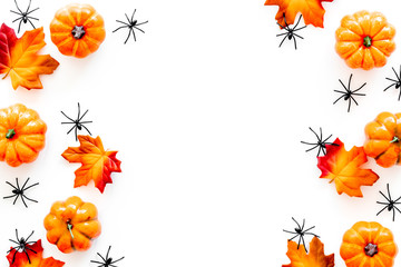 Obraz premium Nice halloween frame. Small spiders among leaves and pumpkins on white top view copy space