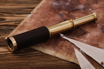 old world map and telescope near sail on wooden surface
