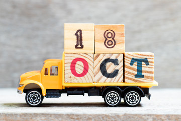 Truck hold letter block in word 18oct on wood background (Concept for date 18 month October)