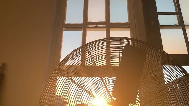 Looking right into the sunset with a lens flare through a metal fan