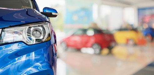 closeup front of new car in showroom background