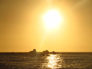 Fototapeta na wymiar A beautiful sunset with the sun approaching the horizon at the sea seen from the beach of Algarrobo, Chili