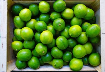 Crate of green limes at a farmers market