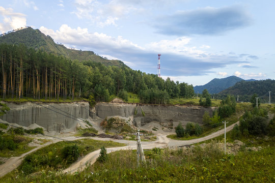 A natural quarry for the extraction of sand, clay near a green forest in the mountains