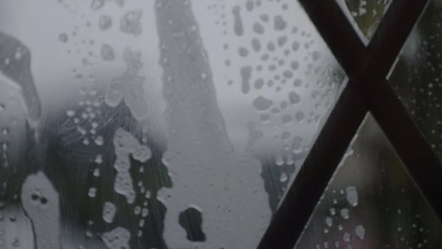 Soapy suds falling slowly down leaded window