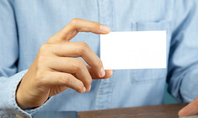 Hand holding a blank piece of paper. Close up white business card,