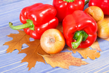 Onions and peppers with autumnal leaves on boards, healthy diet, nutrition and seasonal concept