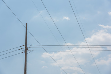Closeup of a cement pole and neat wires network in blue sky background