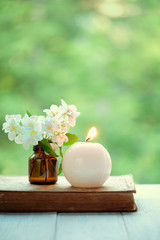 jasmine flowers and candle. beautiful tender scene with candle, white flowers, old book. spring or summer romantic vintage still life. copy space. 