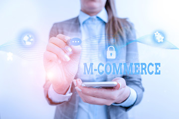 Word writing text M Commerce. Business photo showcasing commercial transactions conducted electronically by mobile phone Female human wear formal work suit presenting presentation use smart device