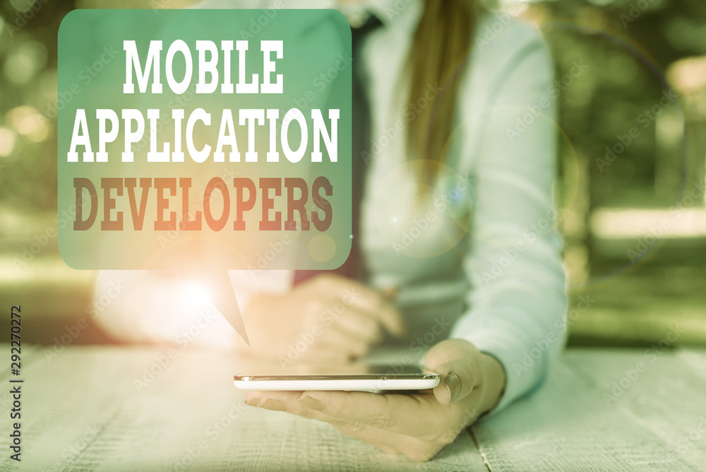 Poster Writing note showing Mobile Application Developers. Business concept for create software for devices like app store Female business person sitting by table and holding mobile phone