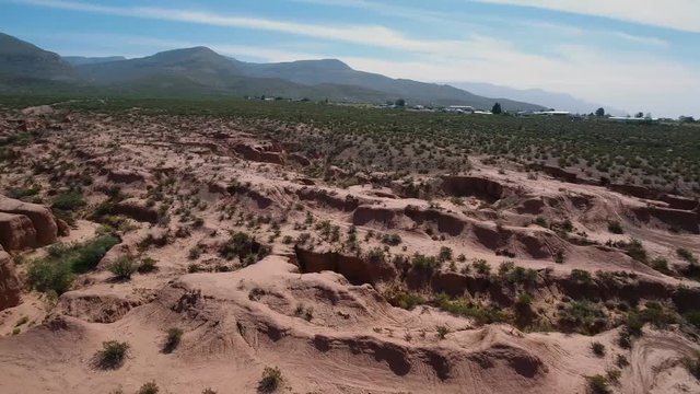 Drone follows vehicle and pans over the desert.