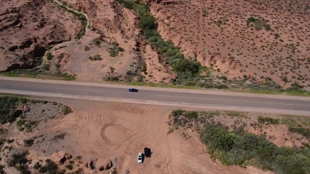 Drone follows vehicle driving through the desert.