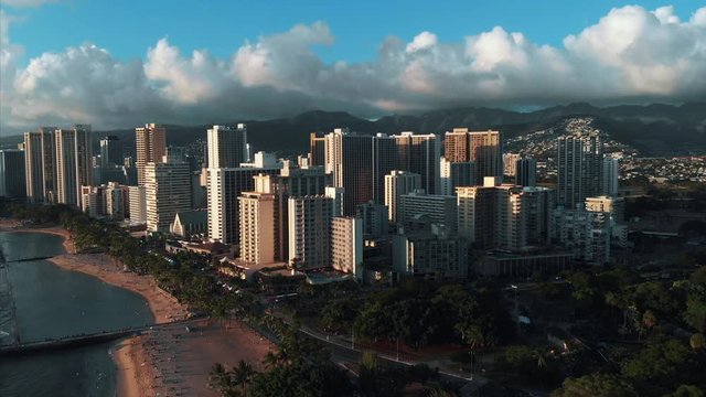 Aerial drone footage of Honolulu, Hawaii. 
Beautiful real estate, buildings in the city. 
Palm trees, ocean and beach.