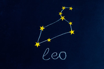 constellation Leo drawn in chalk and gold stars on a chalkboard looking like a night starry sky