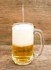glass of beer on wooden background